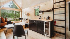 A modern kitchen with a large window, wooden cabinets, and a built-in oven.