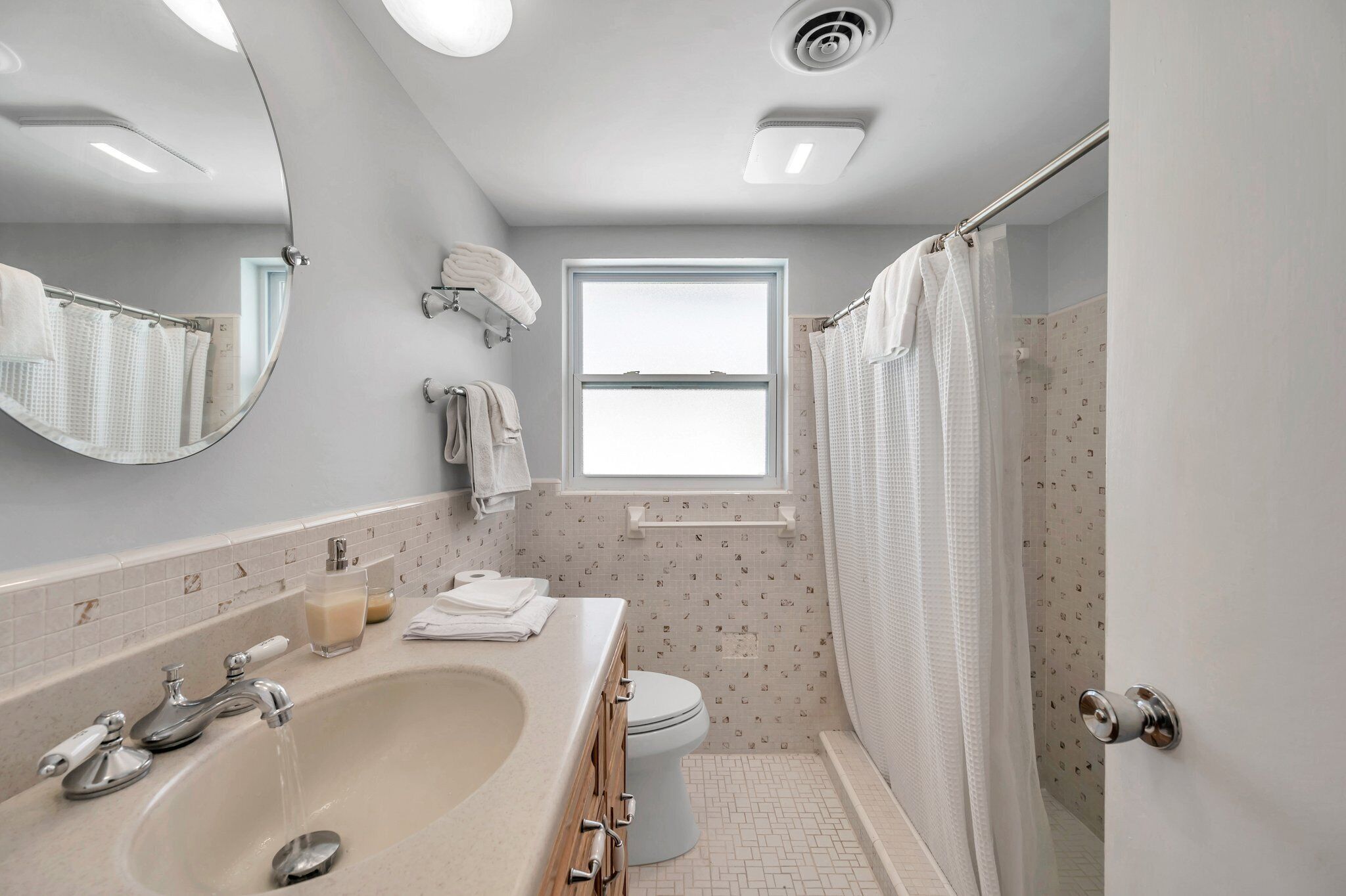 A modern bathroom with a large sink, toilet, and shower area.