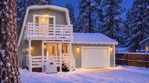 A two-story cabin with a balcony, a garage, and a covered outdoor seating area. - Big Bear Cabin Fire Pit, Grill & Trail Access (Big Bear)