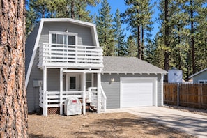 A two-story house with a balcony, a garage, and a fenced yard. - Big Bear Cabin Fire Pit, Grill & Trail Access (Big Bear)