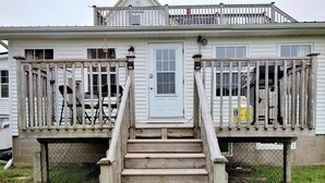 A wooden staircase leading to a white house with a balcony and a door. - Riverside Retreat of Mavillette (Mavillette)