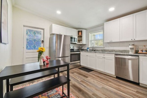 Enjoy meals in this kitchen with stainless steel appliances and a dining table.