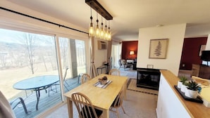Una sala de estar moderna con comedor, ventanas amplias y chimenea.