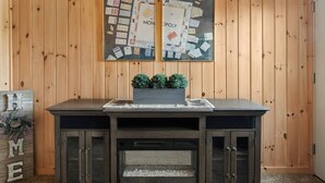 A wooden-paneled room with a dark-colored cabinet featuring glass doors and a built-in shelf. - Peaceful townhome in sought-after Stowe location (Stowe)