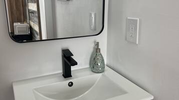 A bathroom with a white sink, black faucet, and a mirror above it.