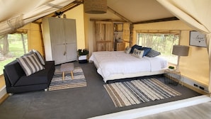 A tented accommodation with a bed, sofa, and wardrobe. - Palumbo Glamping & Villas (Cangahua)