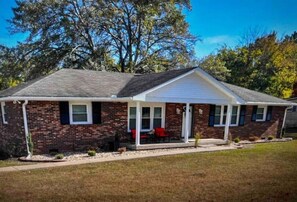 Stroll up to this charming single-story home with a covered porch and a beautifully manicured lawn.