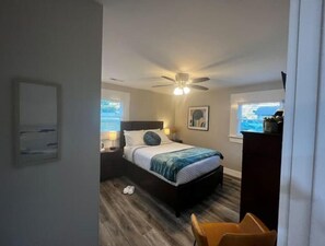 Cozy retreat with a single bed, ceiling fan, and a window offering a view of the outdoors.