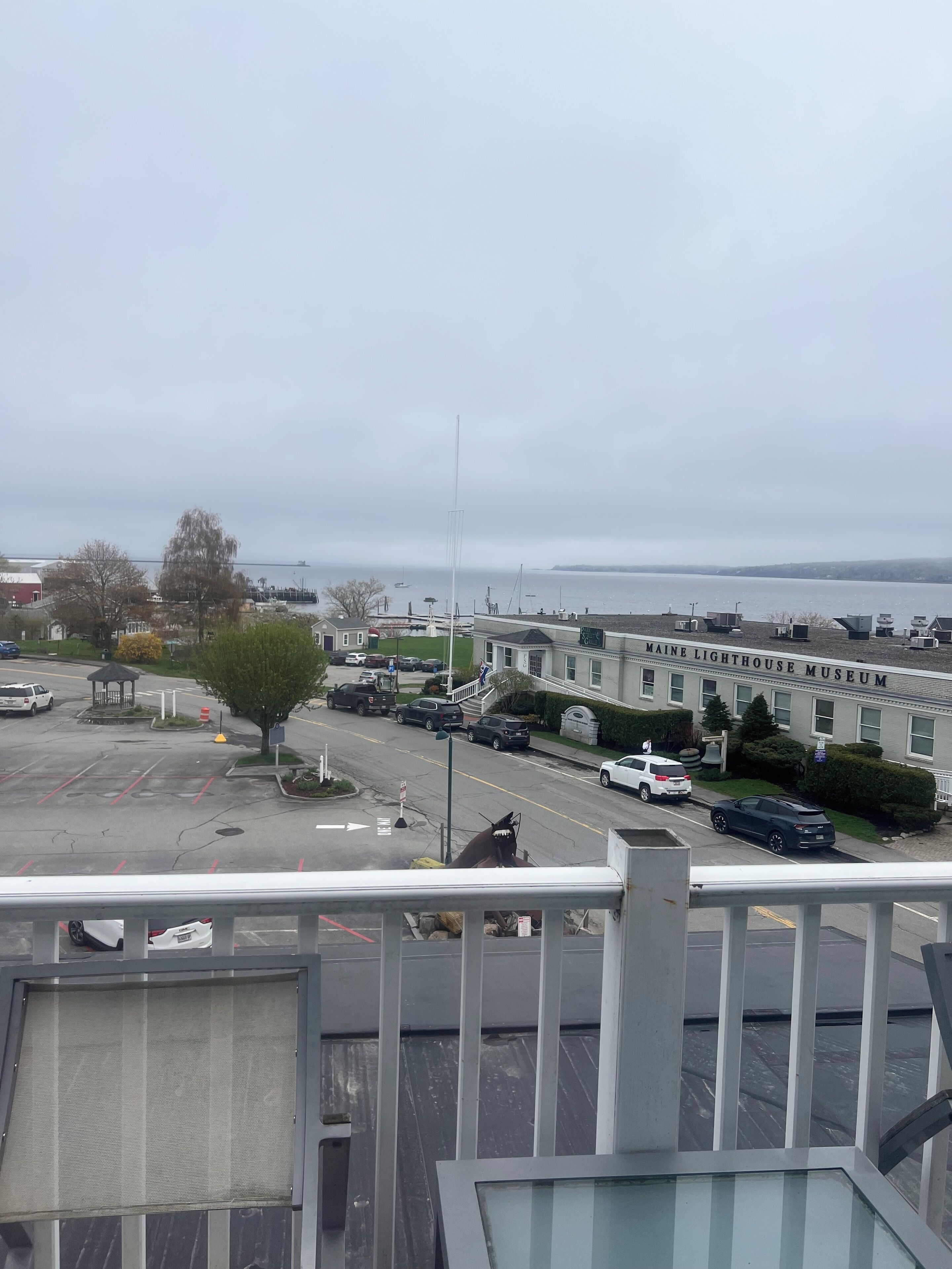 A view from a balcony overlooking a parking lot with a building labeled "MAINE LIGHTHOUSE MUSEUM" in the background.
