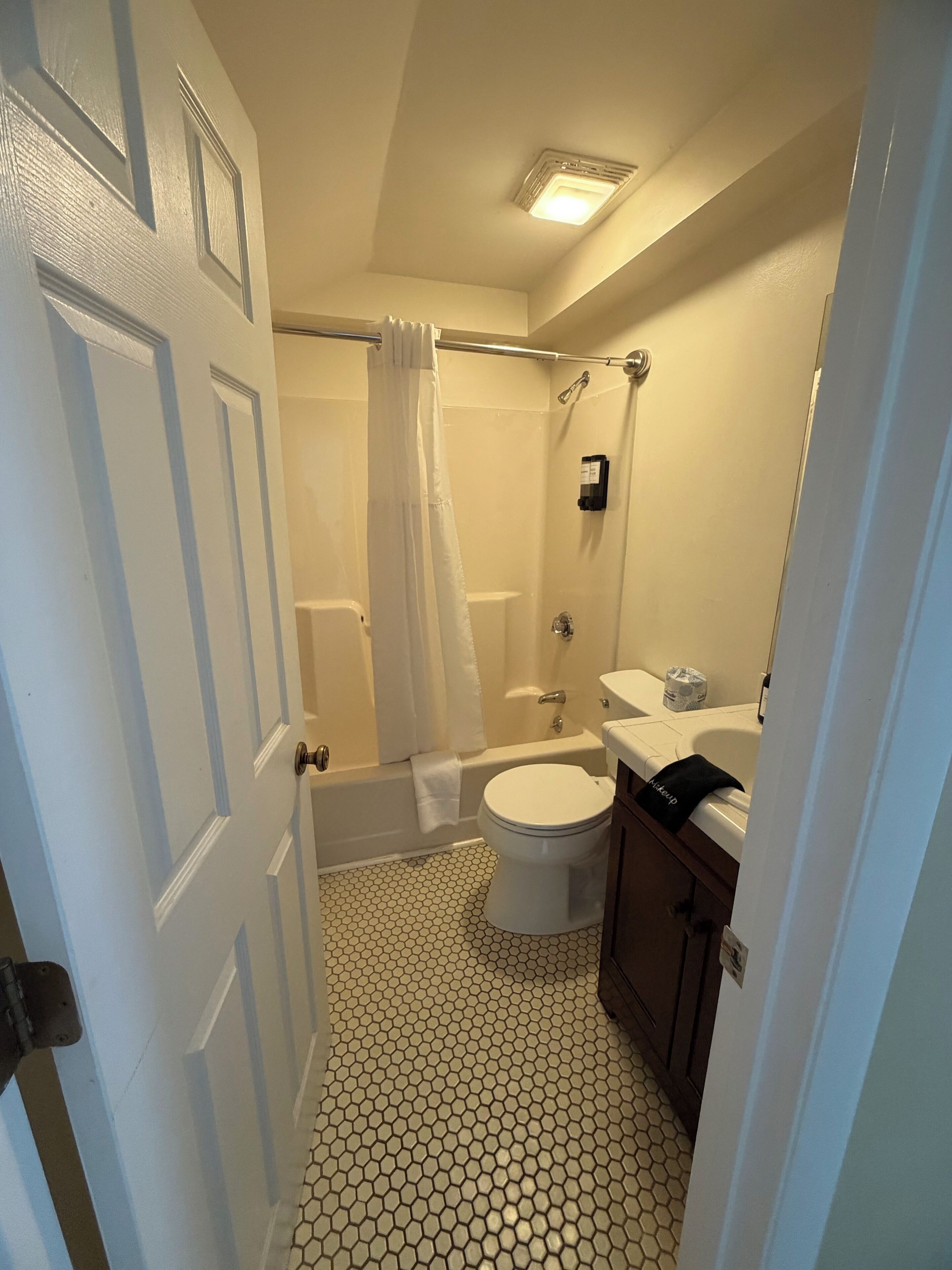 A bathroom with a toilet, bathtub, and shower.