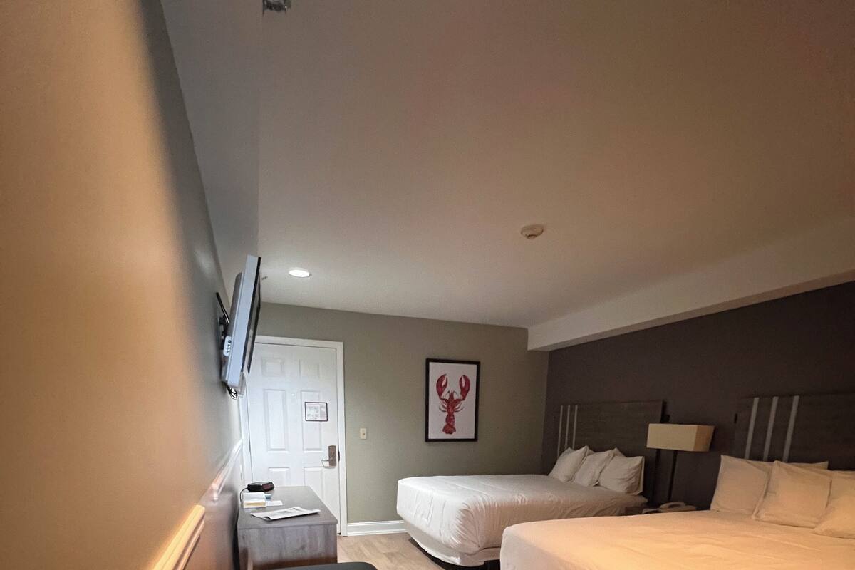 Ein Hotelzimmer mit Bett, Nachttisch, Schreibtisch und Stuhl.