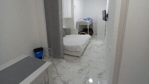 A narrow hallway with a bed, a desk, and a TV. - Apartment Giorgia 1 (Campofelice di Roccella)