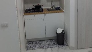 A compact kitchen with white cabinets, a countertop, a sink, and a trash bin. - Apartment Giorgia 1 (Campofelice di Roccella)