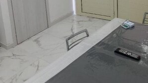 A room with a marble floor, a black table, a remote control, and two doors with frosted glass panels. - Apartment Giorgia 1 (Campofelice di Roccella)