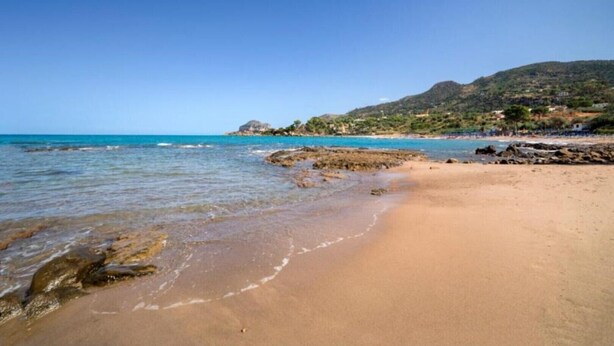 A beach with clear blue water, sandy shore, and rocky outcrops. - Apartment Giorgia 1 (Campofelice di Roccella)