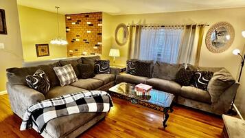 A living room with two sofas, a coffee table, and a brick accent wall.