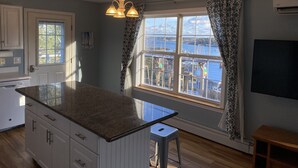 Una cocina con un amplio ventanal, una isla integrada y vistas a un cuerpo de agua.