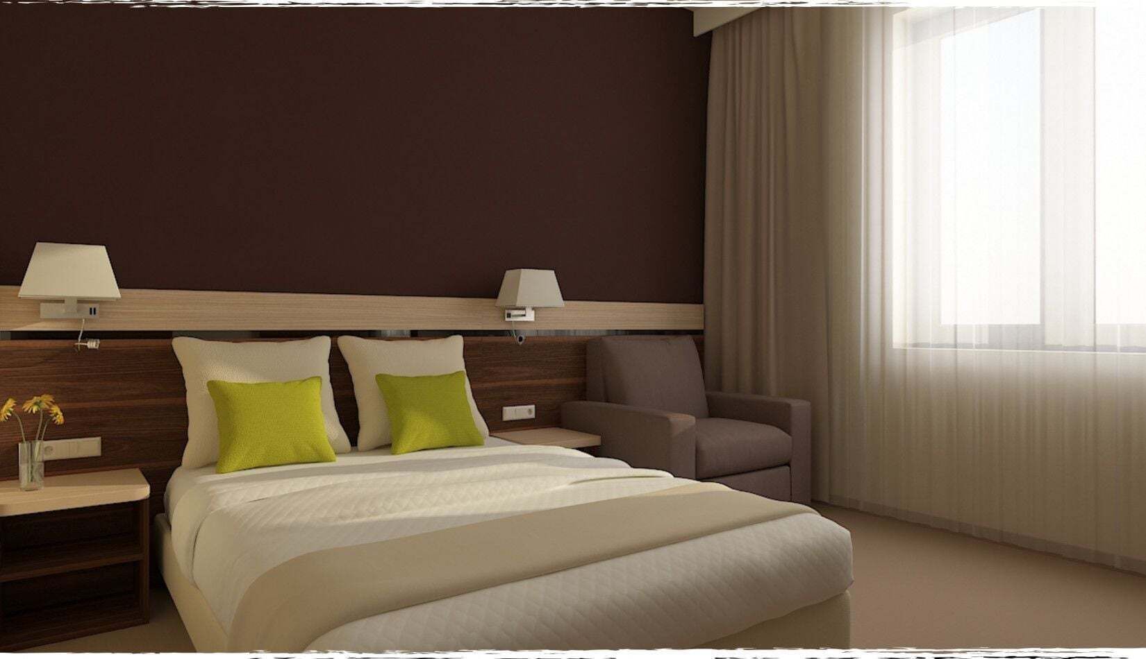 Et hotelværelse med en stor seng, to sengeborde med lamper, en stol og et vindue med gardiner.
