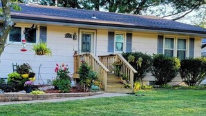 A single-story house with a front porch, a staircase leading to the entrance, and a well-maintained lawn.
