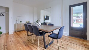 A dining area with a wooden table, six chairs, and a cabinet with decorative items.