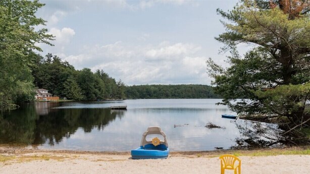 A lakeside scene with a boat and a chair on the shore. - Beaver Lake Escape
 (Rock Hill)