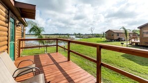 Eine Holzterrasse mit Blick auf einen See und umliegende Gebäude.