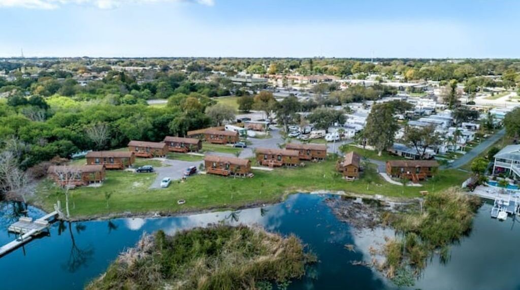 A residential area with brick houses, a small pond, and a dock.