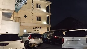 A multi-story building with 'ARDA HOTEL' signage, several parked cars, and a balcony on the upper floor. - Hotel Arda Bali (Negara)