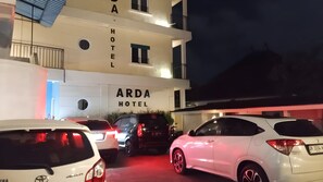 ARDA HOTEL -niminen hotelli, jossa on moderni julkisivu, useita ikkunoita ja pysäköintialue, jossa on useita autoja.