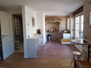 A kitchen with a brick wall, a white countertop, and a window.