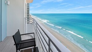 Ein Balkon mit Blick auf Strand und Meer.