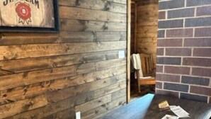 Un mur en bois sur lequel est accroché un panneau encadré portant l’inscription « Jim Beam ».