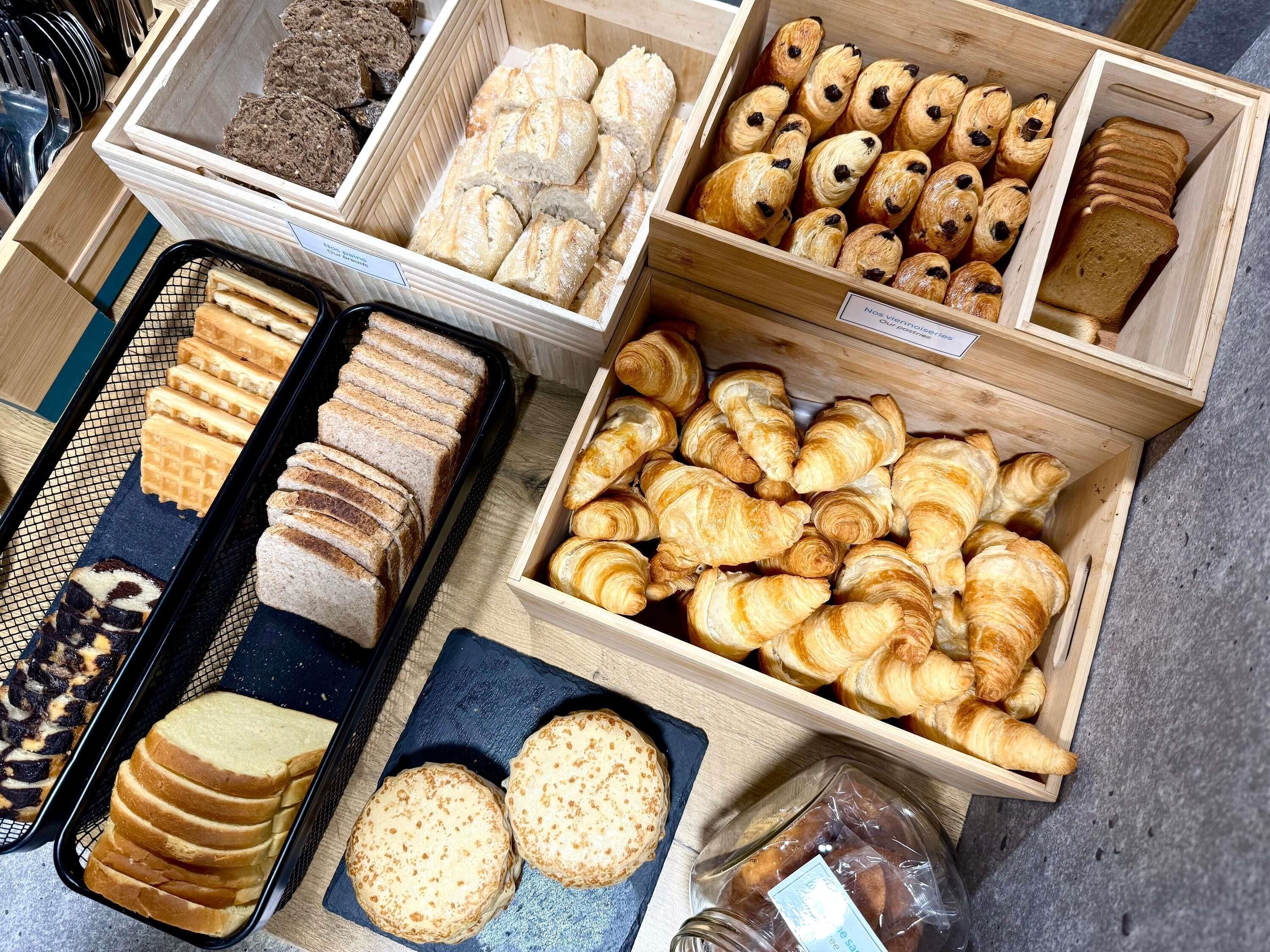 Diversas opciones de productos horneados presentados en cajas y bandejas de madera.