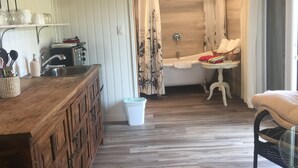 A bathroom with a bathtub, a sink, and a chair.