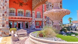 Un bâtiment historique doté d’une fontaine, de murs en pierre et d’une cour intérieure.