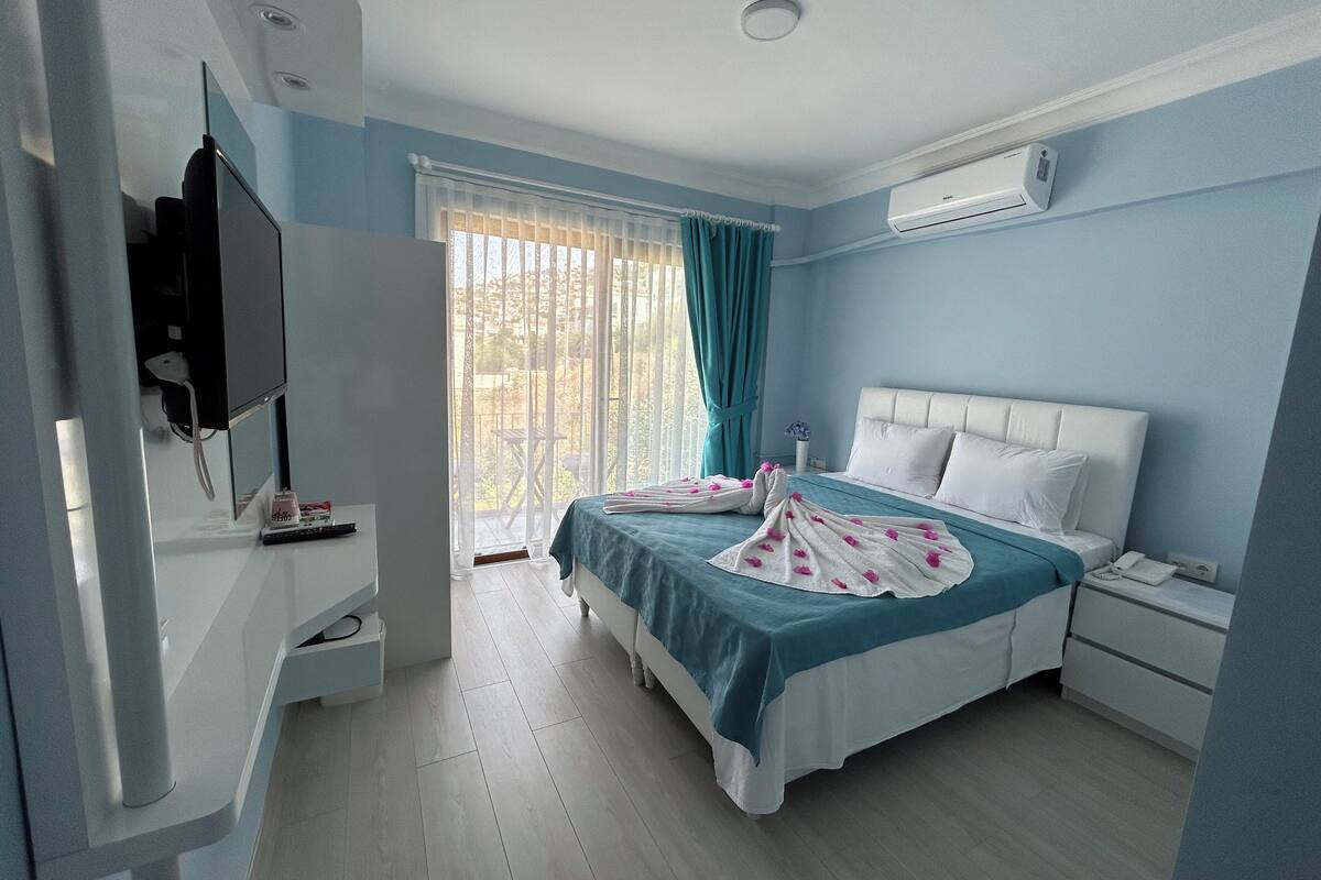 Een slaapkamer met een bed, nachtkastje, en een airconditioning.