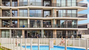 A multi-story hotel with balconies, a swimming pool, and outdoor seating areas. - Lovely apartment in Oostende (Oostende)