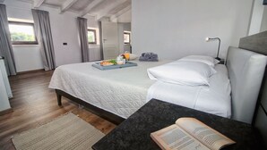 Een hotelkamer met een bed, nachtkastje en een raam.