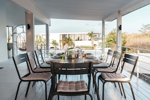 A dining area with a table set for six, surrounded by chairs with cushioned seats.
