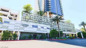 A hotel with a modern facade, featuring the name 'PALMS PLACE' prominently.