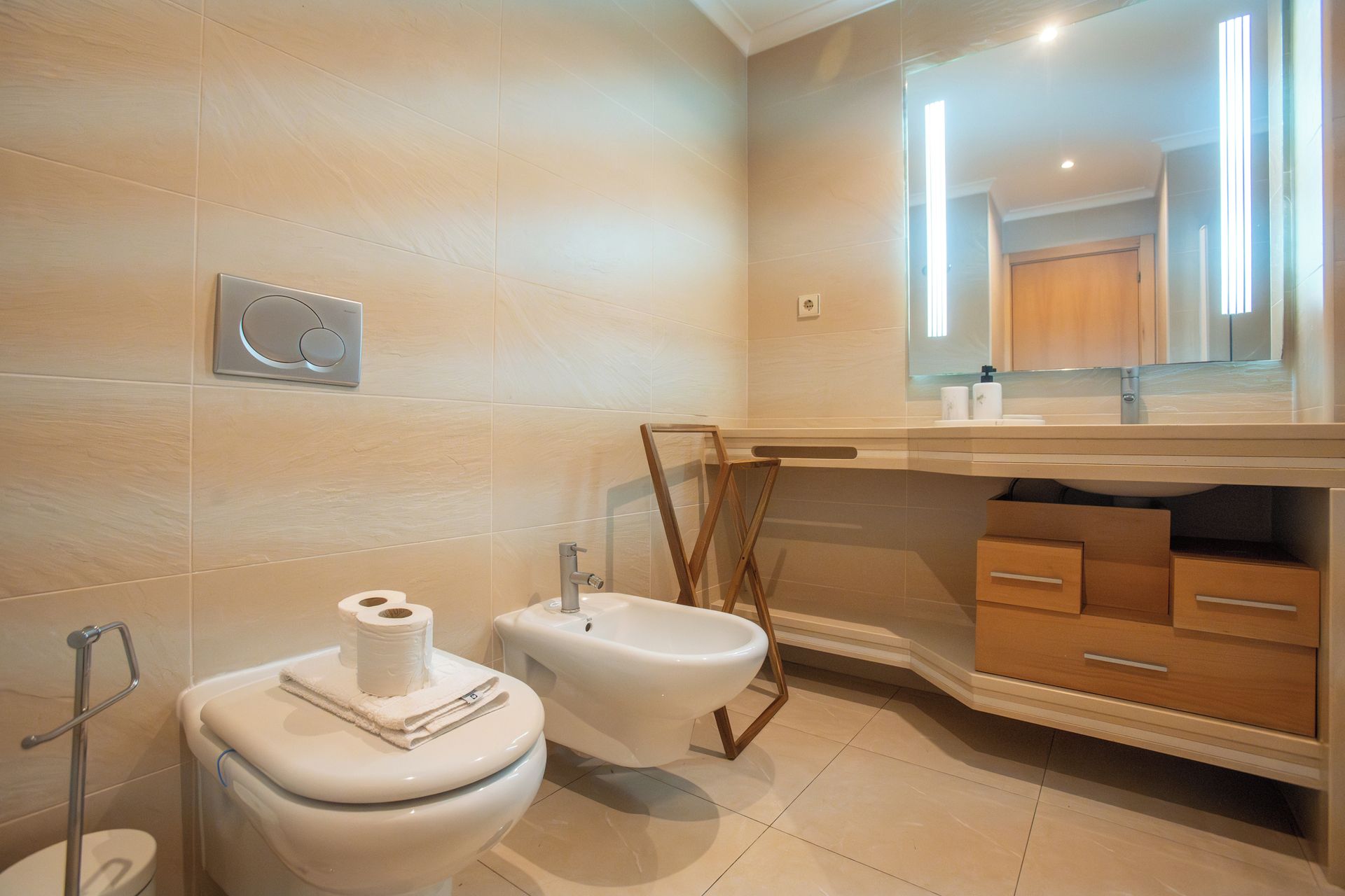 Une salle de bain moderne équipée de toilettes, d’un bidet et d’un meuble-lavabo avec des tiroirs.