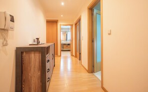 A hallway with wooden flooring, a wooden cabinet with drawers, and a telephone on the wall. - Modern 2 bedroom flat in Odivelas (Odivelas)