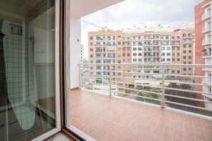 A balcony with a view of a multi-story residential building.