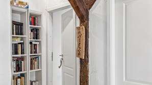 Una porta bianca con una targa di legno con il nome DANIELE e una libreria piena di libri.