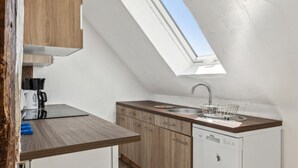 Una cucina compatta con una finestra sul tetto, una macchina da caffè e un lavastoviglie.
