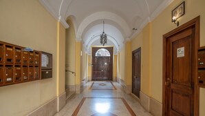 A hallway with a marble floor, wooden lockers, and a chandelier. - Trastevere at heart.. (Roma)