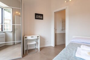 A modern bedroom with a bed, a desk, and a walk-in closet. - Trastevere at heart.. (Roma)
