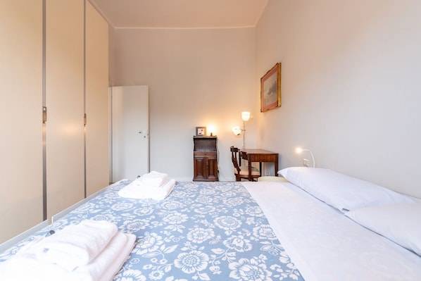 A bedroom with a bed, a wardrobe, a desk, and a chair. - Trastevere in the heart of the city. (Roma)