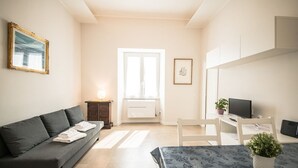 Een moderne woonkamer met een bank, een eettafel en een televisie.