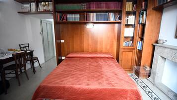 Un dormitorio con cama, estanterías de madera, un escritorio y una silla.